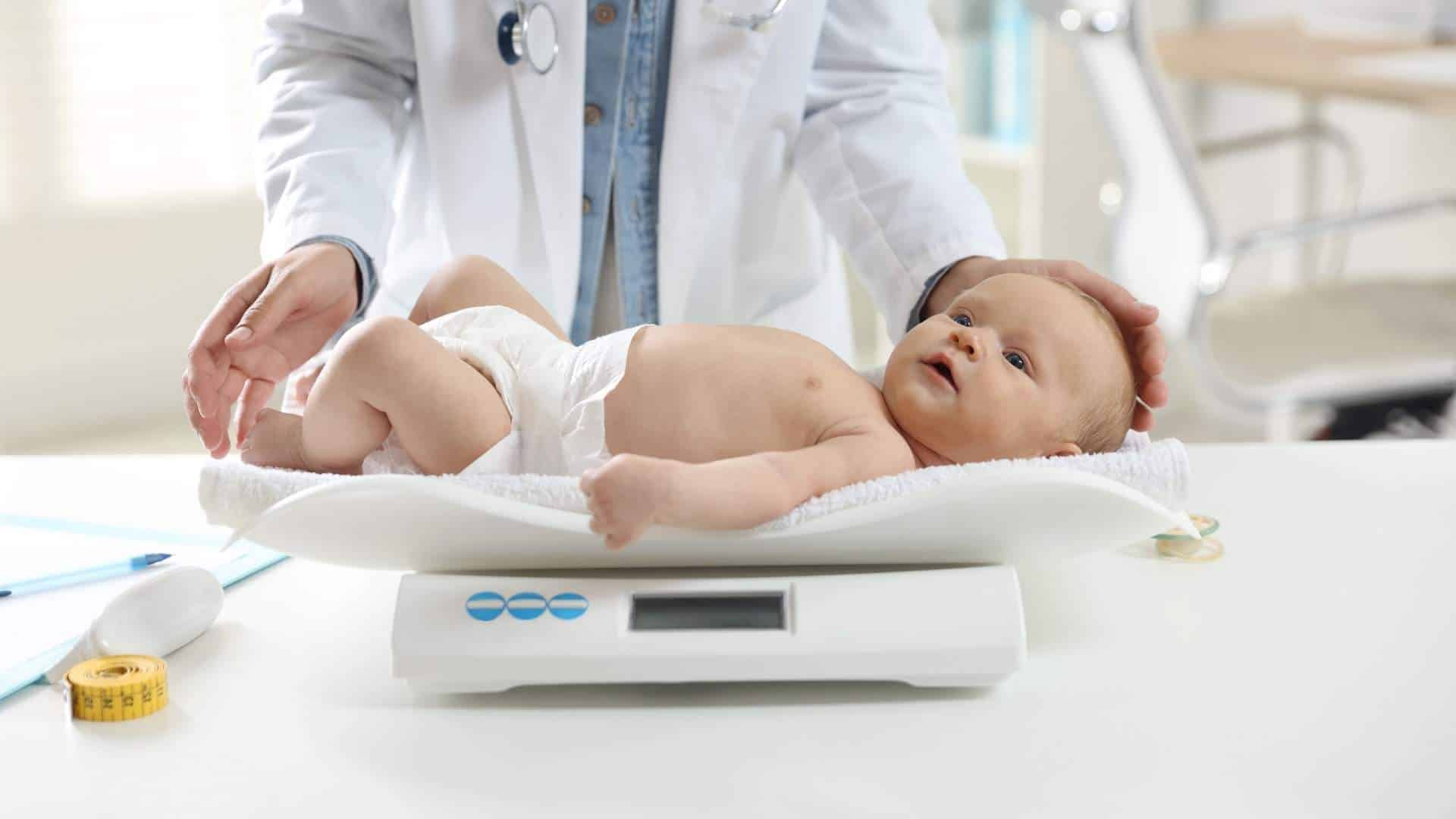 Neonato durante una visita di controllo sulla bilancia pediatrica per il calendario visite del primo anno a Paradiso, Svizzera