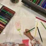 Bambino impegnato in un'attività di disegno e espressione delle emozioni attraverso l'arte e i colori in un atelier creativo