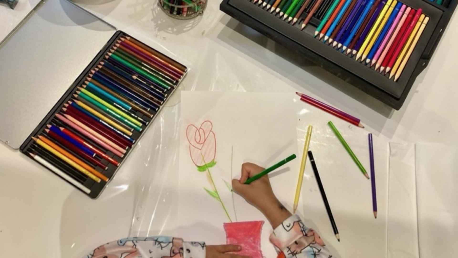 Bambino impegnato in un'attività di disegno e espressione delle emozioni attraverso l'arte e i colori in un atelier creativo