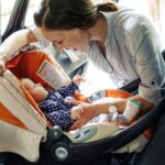 madre mette l'ovetto in sicurezza il bambino in macchina